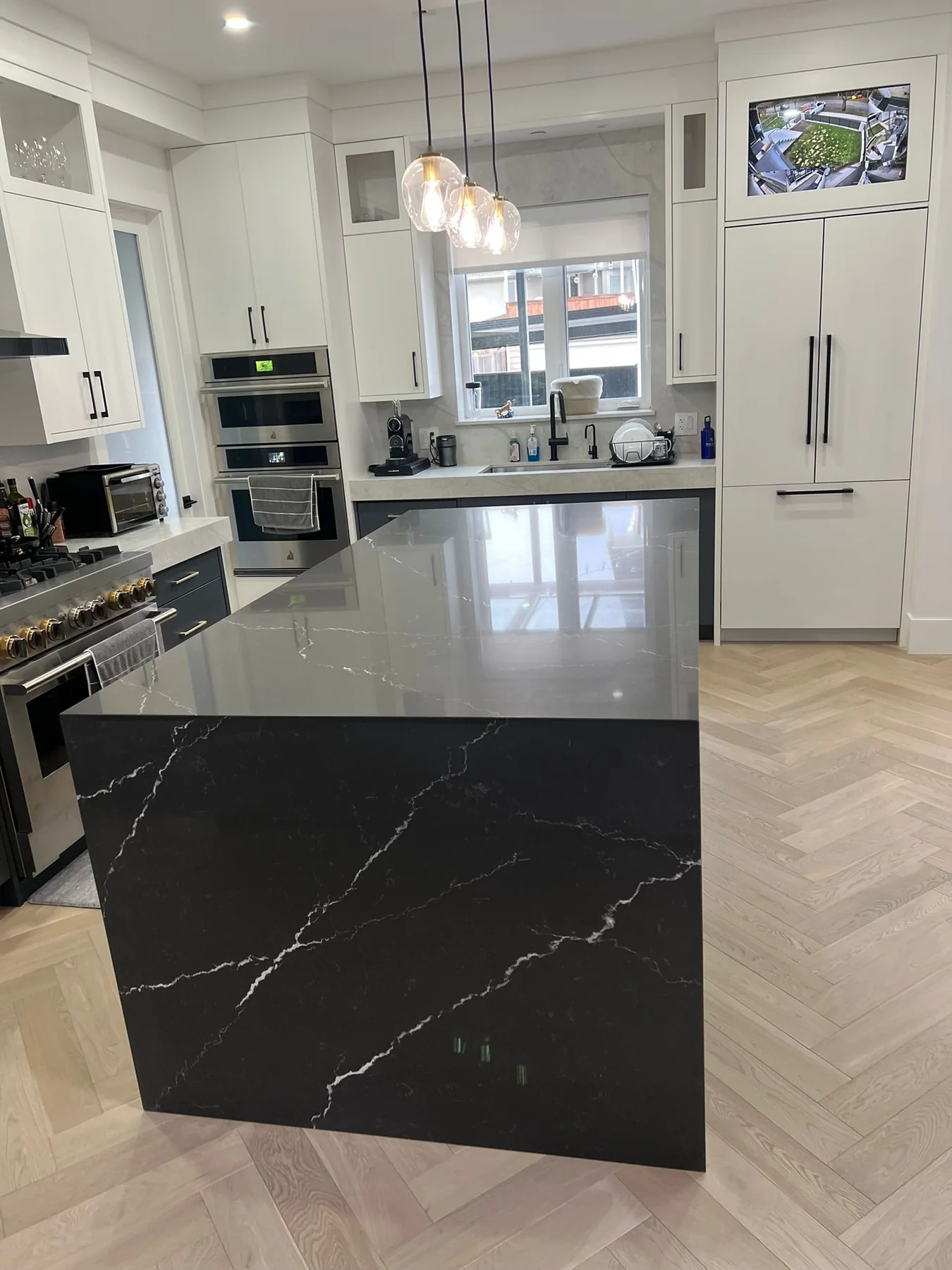 Kitchen with black floor tile and stone countertops.