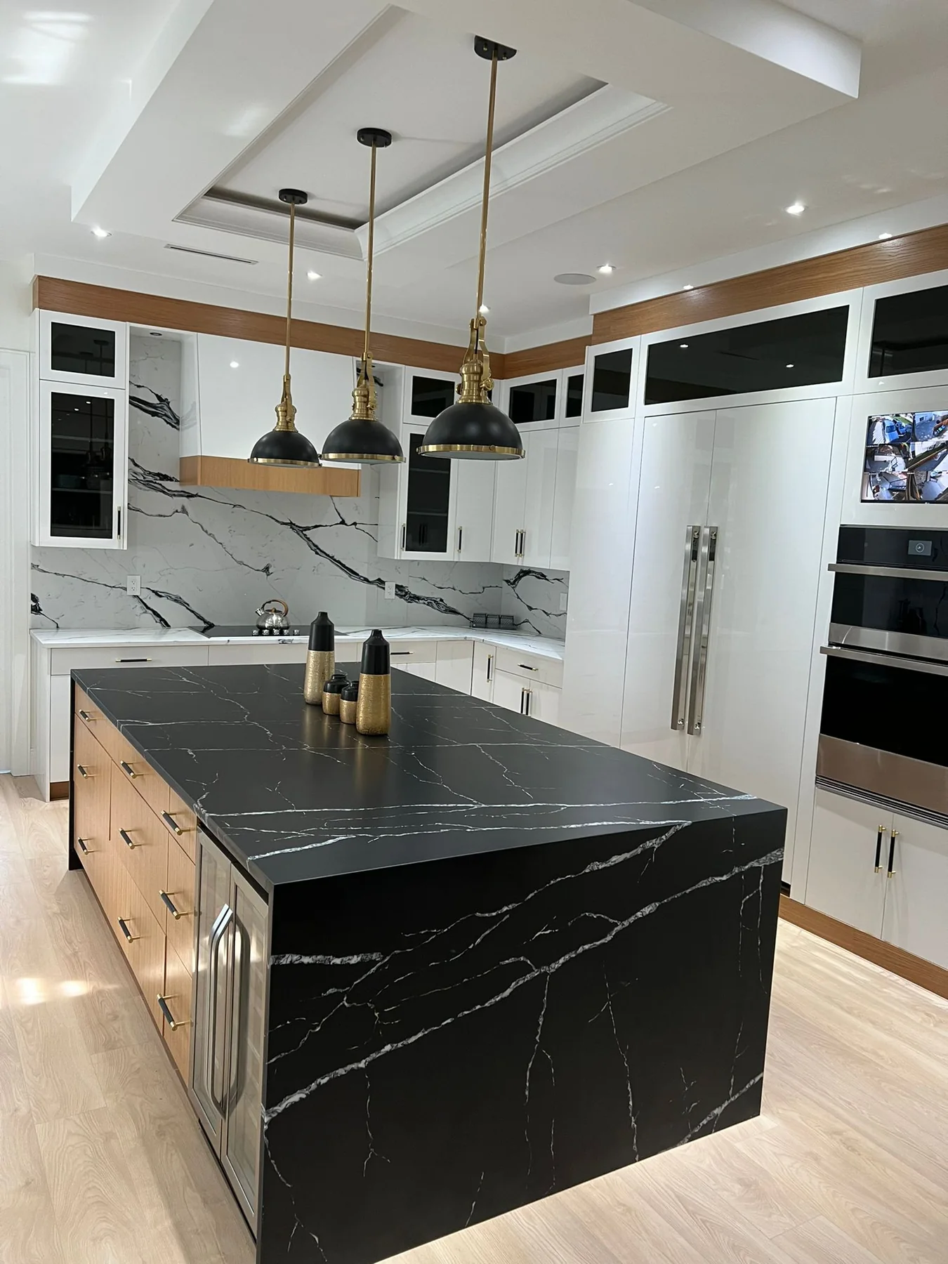 Black waterfall kitchen island with white veining.