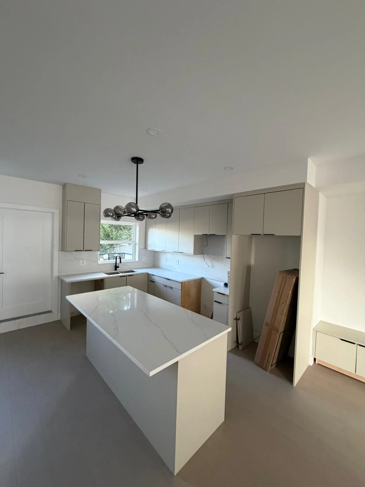 Bright kitchen with white waterfall island countertop.
