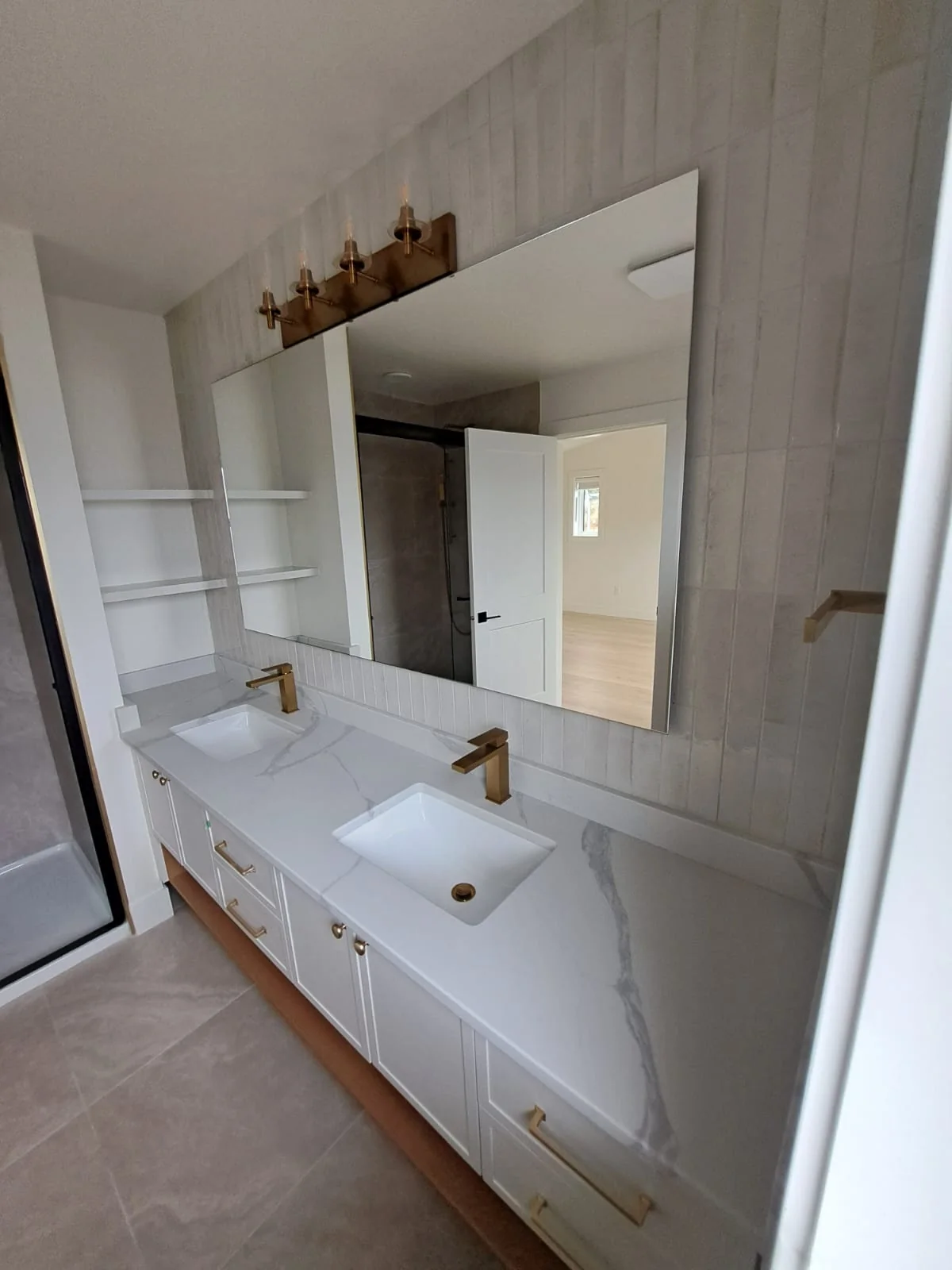Double bathroom vanity with light stone countertop.