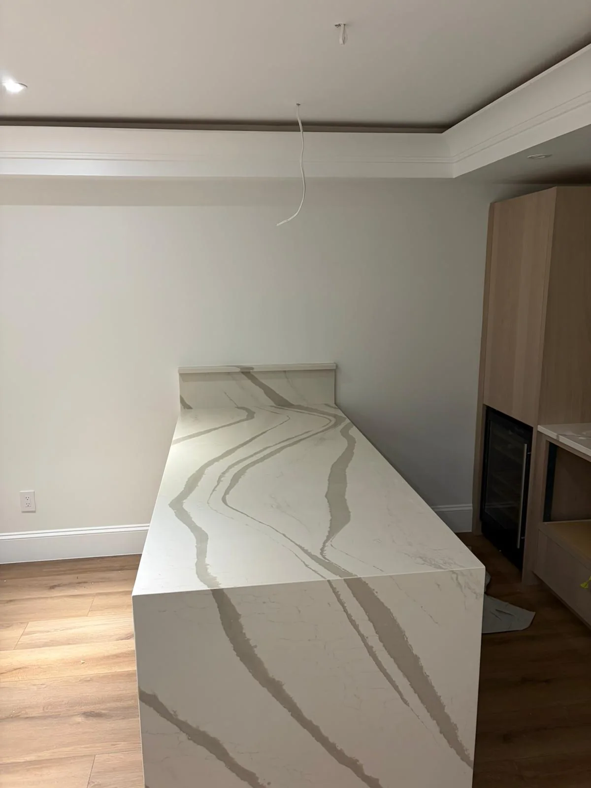 Close detail of a waterfall countertop edge with stone veining.