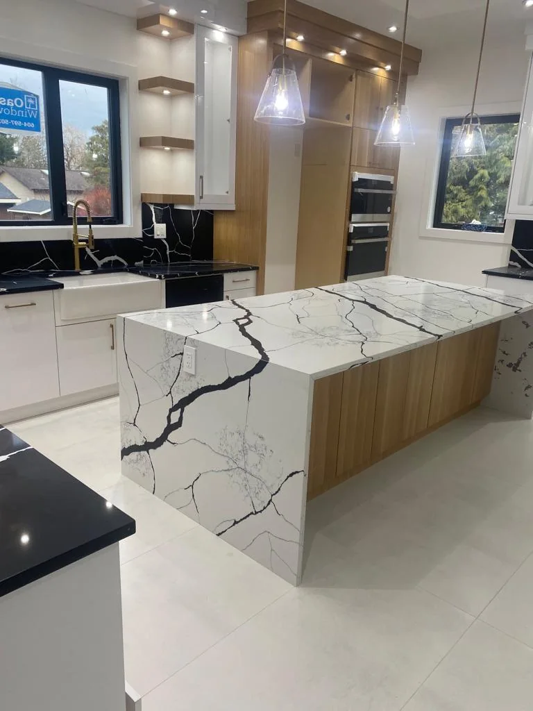 Waterfall kitchen island with marble-look veining.