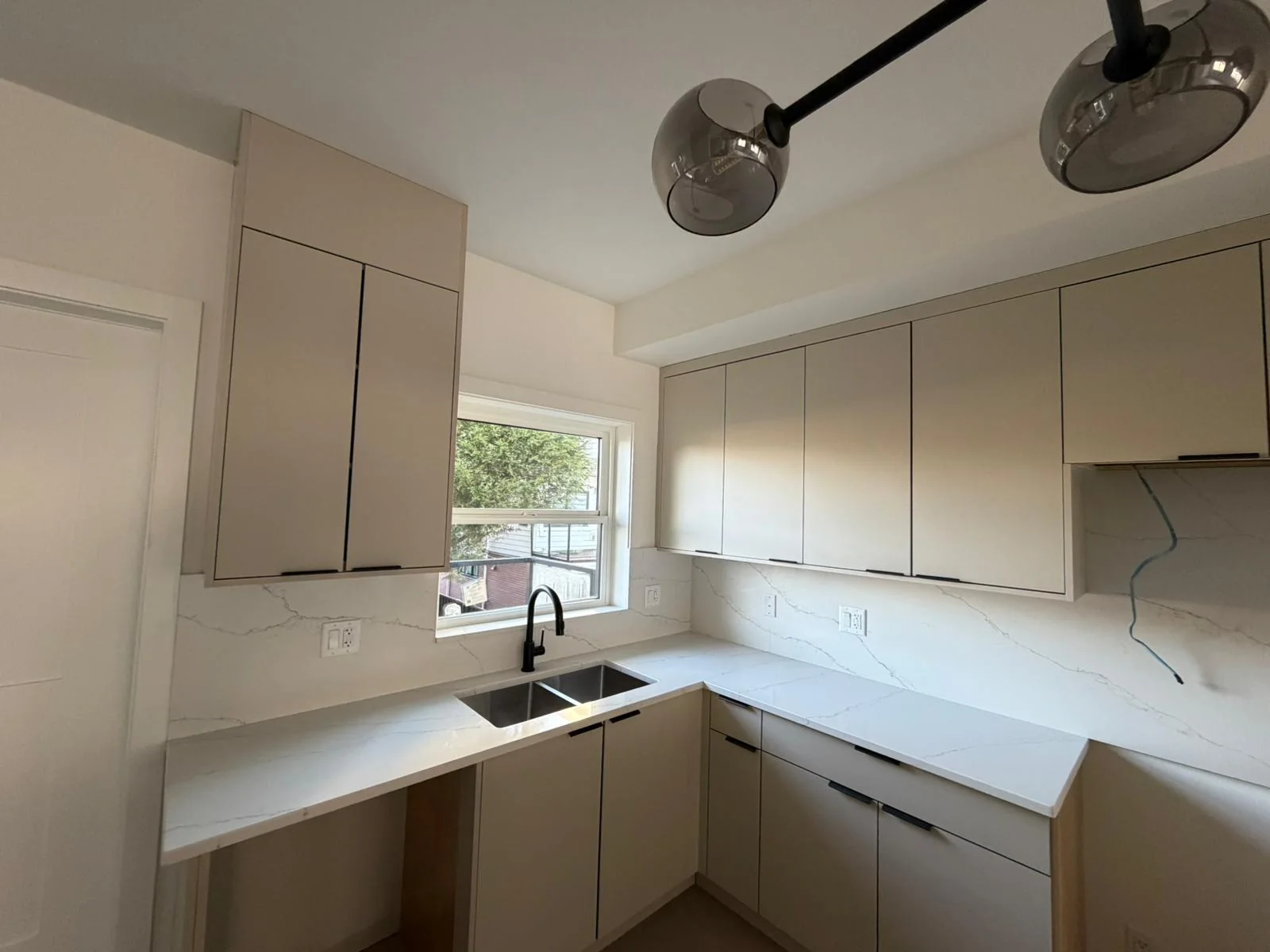 White kitchen countertop installed around cabinets and sink.